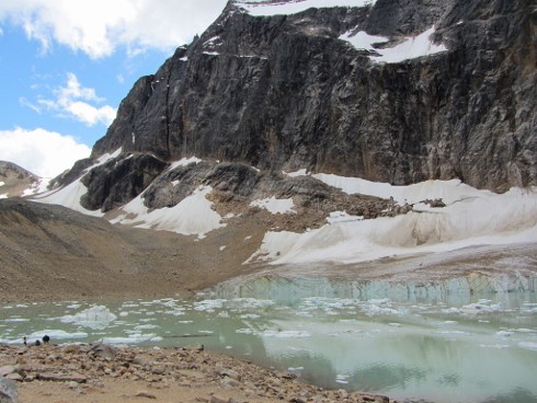 black mountain with snow and a frozen lake shot from a road trip canada