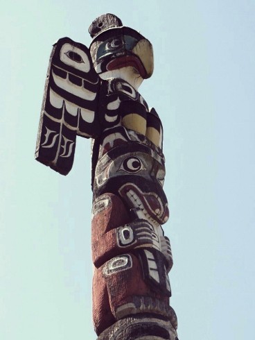 old totem pole with several animals topped with an eagle