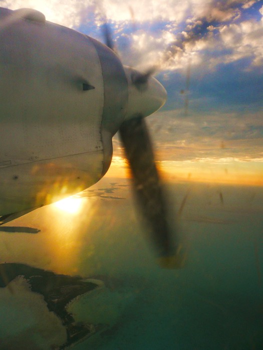 sunset picture from a plane window with a large part of the plane in the picture