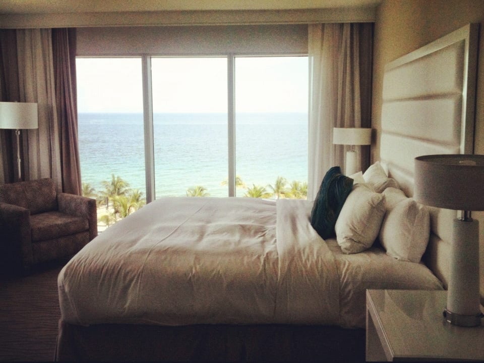 Hotel room view of the sea with a bed and chair