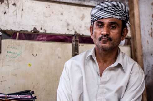 Tobacco seller in Muscat. Man with traditional headdress staring into camera