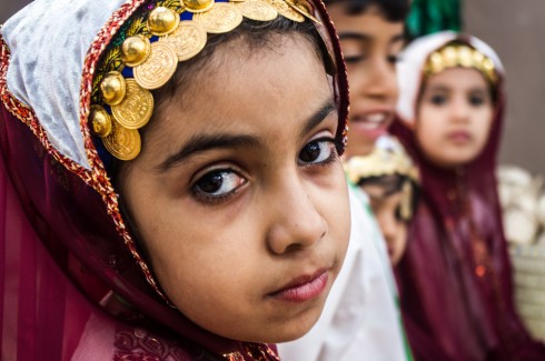 Young Omani girl in traditional dress looking into the camera