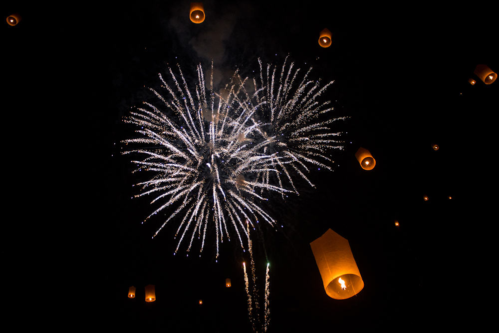 Papierlaternen und Feuerwerk erhellen den Nachthimmel