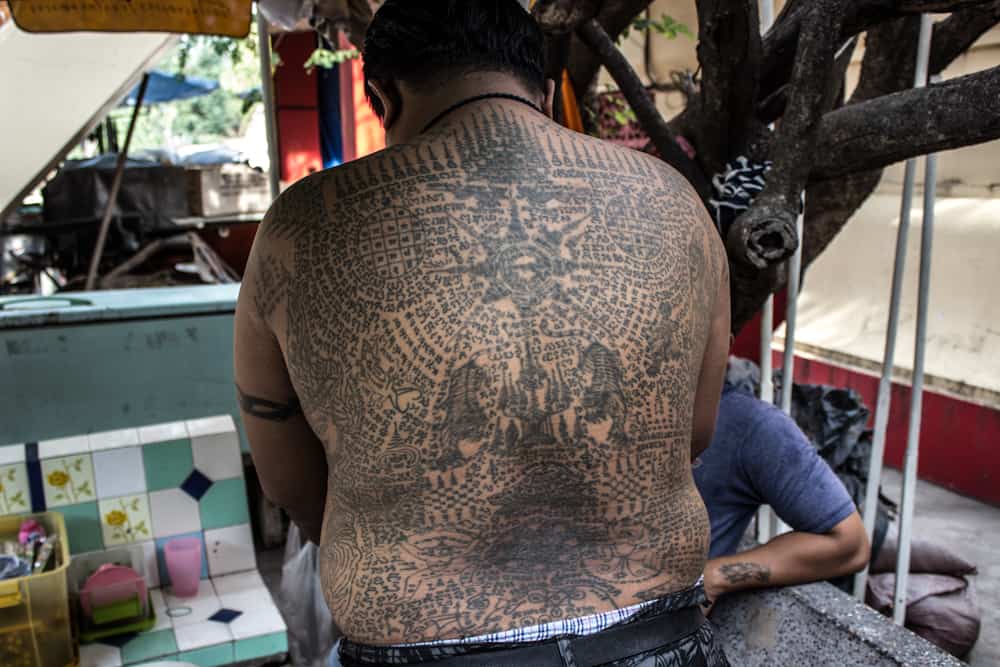 A man showing the tattoo on his back