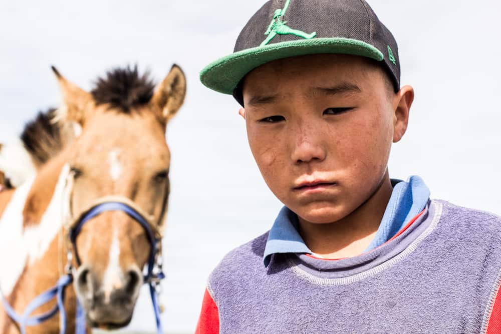 small frowning boy with his horse 