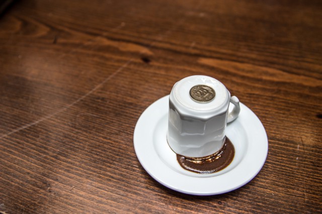 a coin on top of a white coffee cup