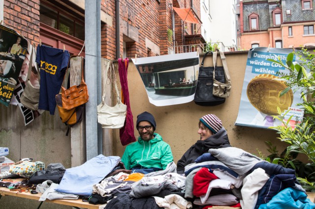 two people sitting outside selling clothes