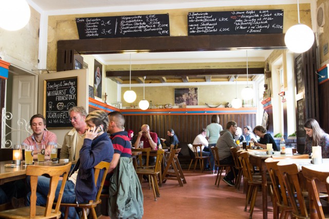 people sitting inside a pub on wooden chairs