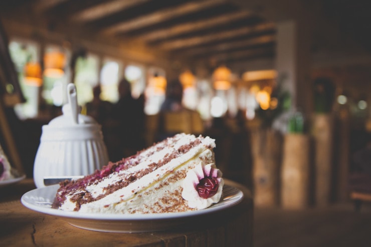 black forest cake of layers of red cake and 
 white icing in a cafe