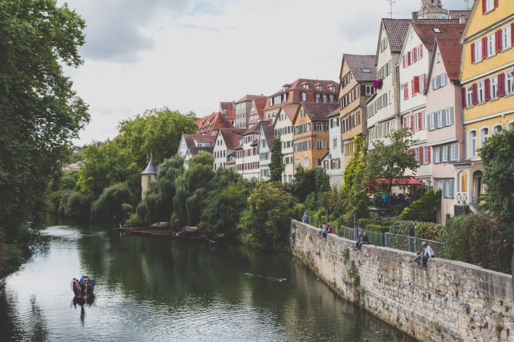 old colorful German houses along a river in Tubingen. Small Boat sailing down the river one of the things to do in Baden-Württemberg