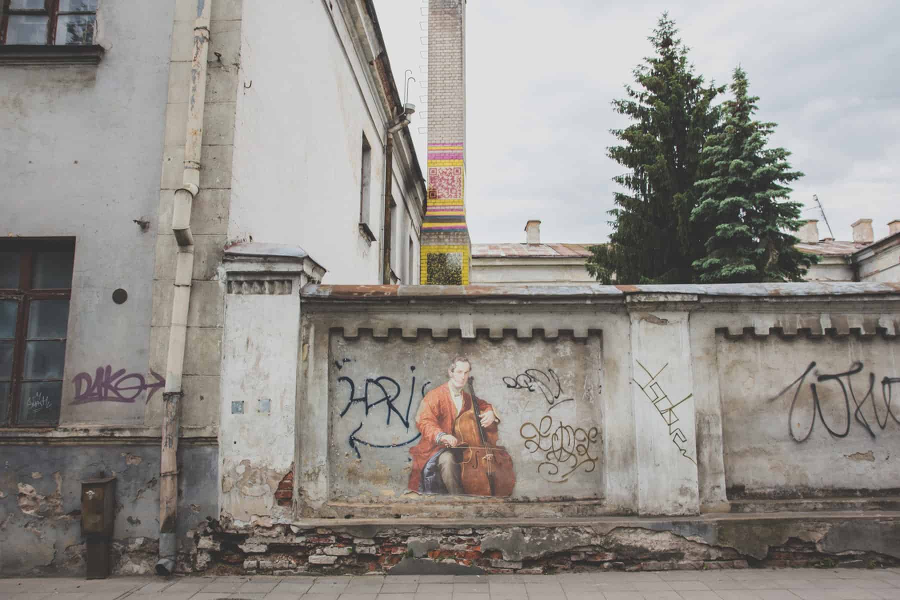 Mann spielt Cello, gemalt zwischen Graffiti