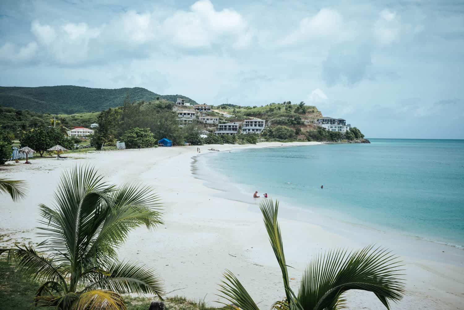 Leerer Strand mit Palmen und blauem Wasser