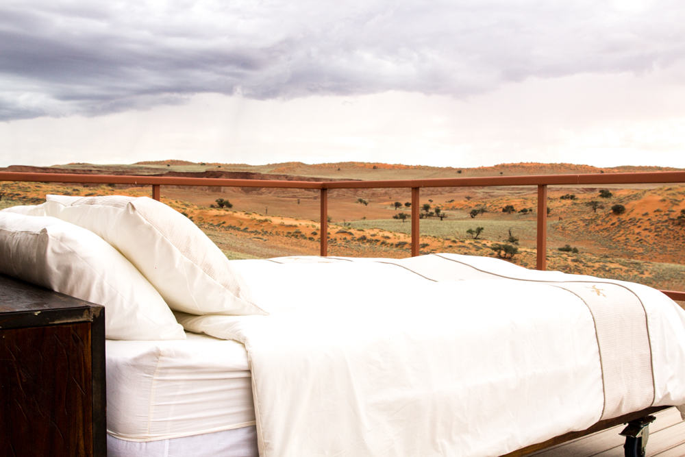 Bed on a balcony in front of desert