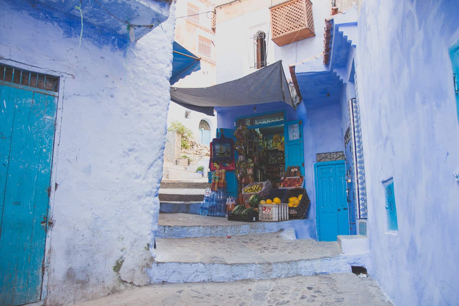 blaues Gebäude mit einem kleinen Markt mit frischem Obst