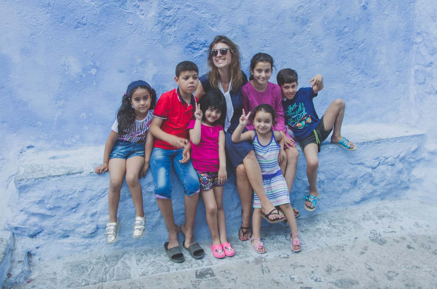 Kinder in einer kleinen Gasse mit blauen Gebäuden in Marokko
