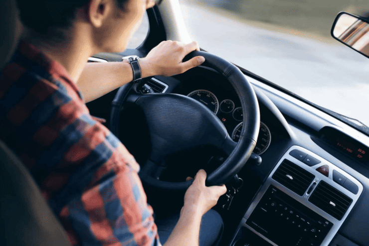 man driving generic car in an orange shirt