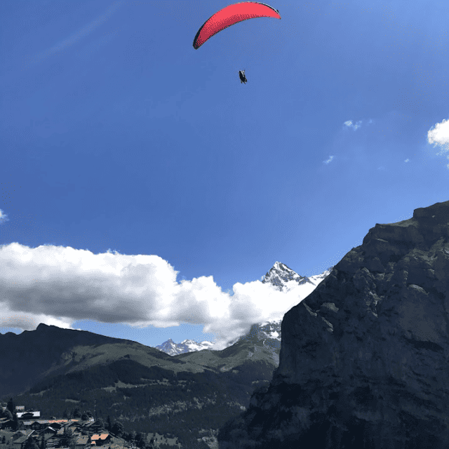 red parachute shown paragliding Switzerland over the Alps