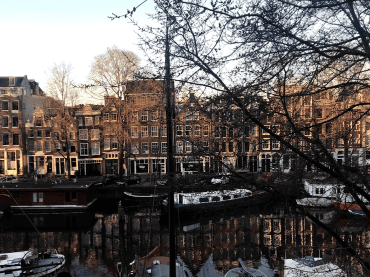 The morning golden sun on Amsterdam Canal Houses with house boats 