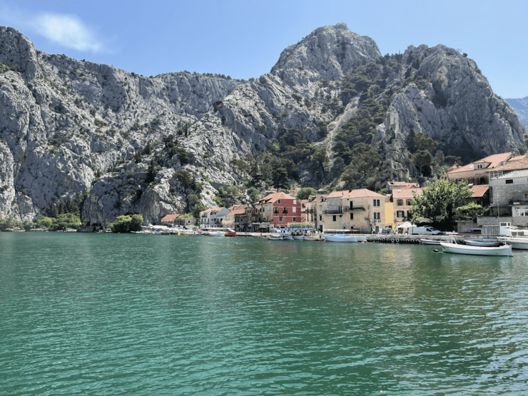 Croatia lake view with mountain range, colorful houses and boats