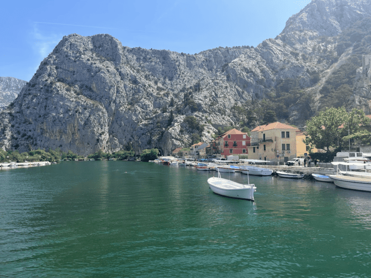 Crystal Blue waters with a mountain range and colorful houses in Omis, Croatia