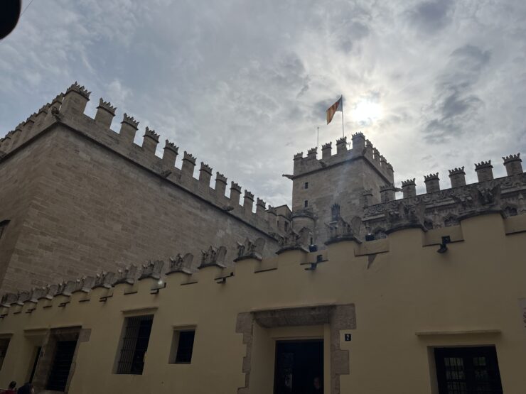 Medieval castle in Valencia with a flag and a cloudy sky