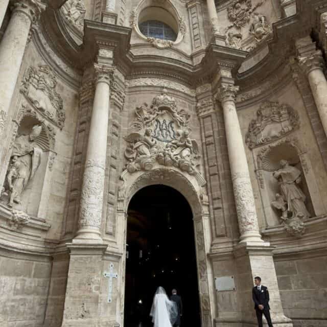 Old Cathedral with bride walking into the door with her father, large columns on both sides of the bride