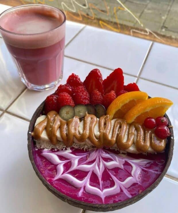 Colorful purple smoothie bowl with a banana, berries and orange at Rainbowls for a vegan brunch amsterdam