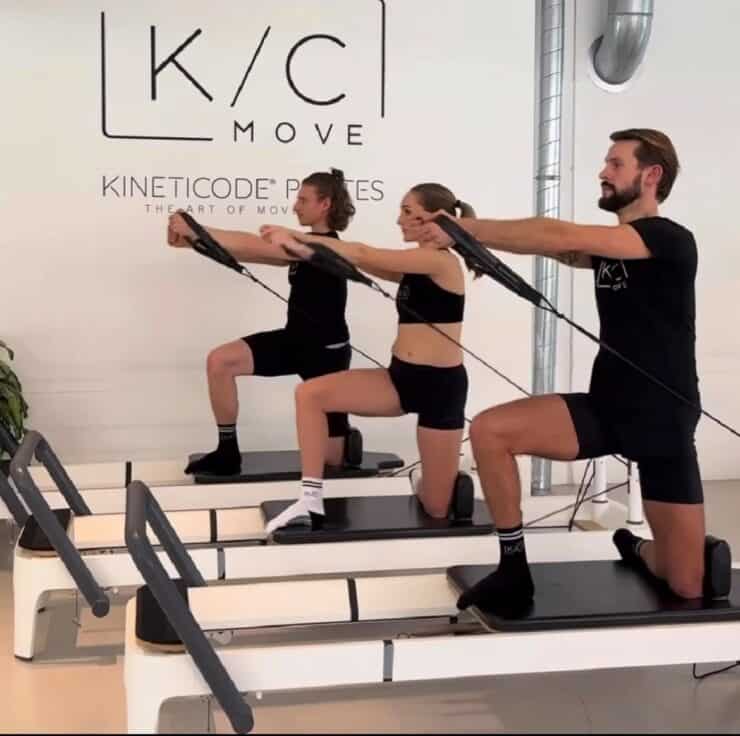 three people do pilates on a reformer