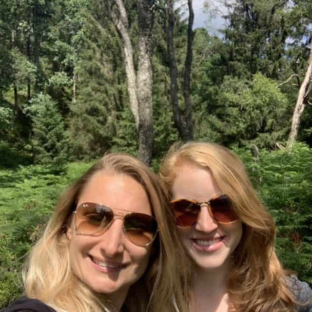 two women smiling in a forest in Saxon Switzerland National Park while wearing sunglasses 