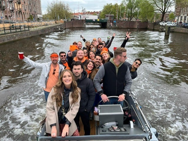 group of people wearing orange clothes on a boat