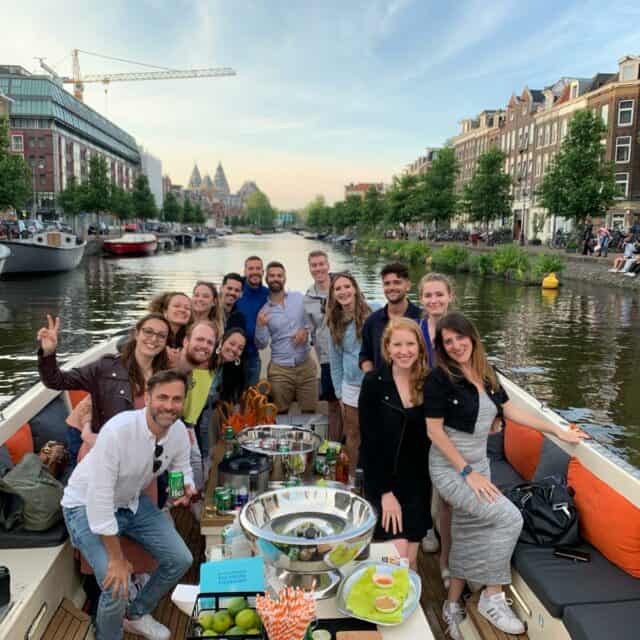 group of people on the best canal tour Amsterdam with drinks