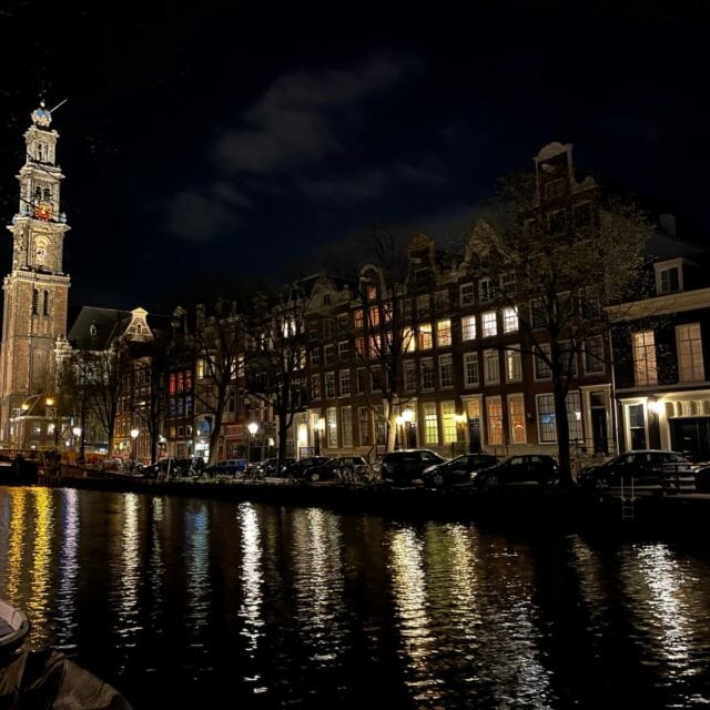 street view at night of buildings and a tower overlooking a canal