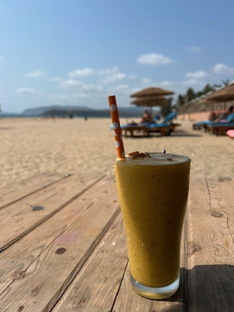 yellow smoothie in a glass on a wooden table