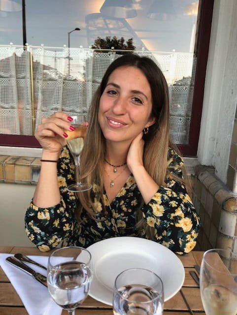 Person sitting at a table with a glass 