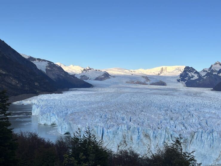 Perito Moreno Glacier - large blue textured glacier with mountain range behind