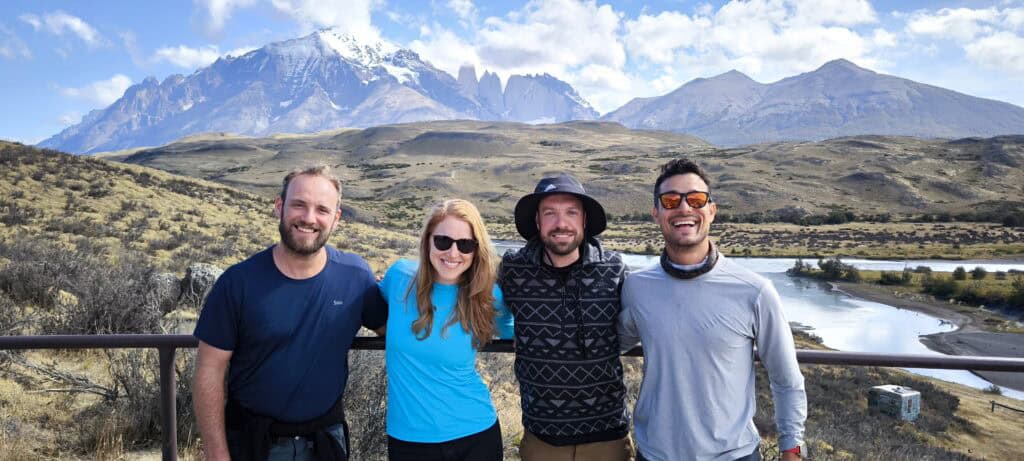 4 people smiling in front of Torres del Paine National Park