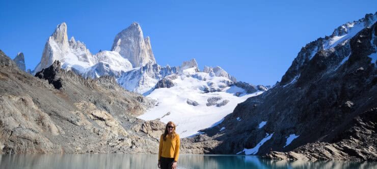 Women Smiling next to a lake with the Fitz Roy Mountain behind her.