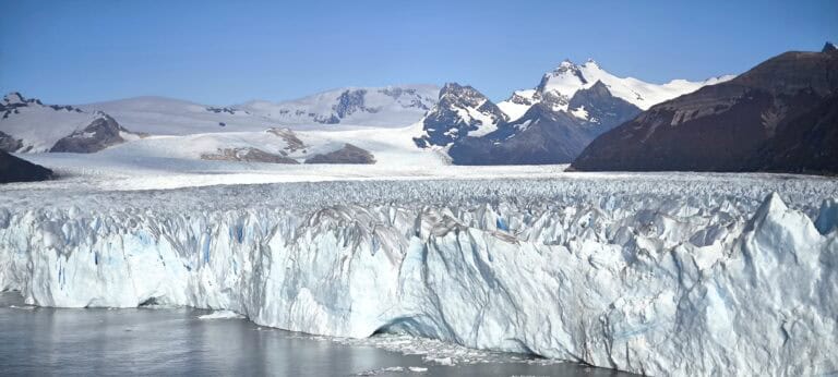 Perito Moreno Glacier - large blue textured glacier with mountain range behind